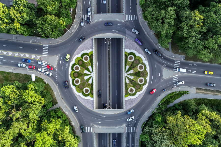 vista dall'alto di uno svincolo autostradale circolare all'interno di un paesaggio boschivo 